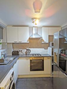 a kitchen with white cabinets and a stove top oven at A Home from Home - Leamington Spa in Leamington Spa