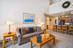 a living room with a couch and a table at Spacious & cheerful Pico slopeside Condo Walk to lift & ski back! Pico 304 in Killington