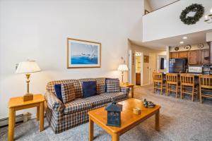 a living room with a couch and a table at Charming 2-Bedroom Slopeside at Pico Mountain E304 in Killington