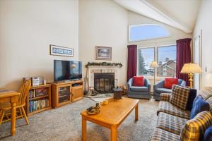 a living room with a couch and a tv at Charming 2-Bedroom Slopeside at Pico Mountain E304 in Killington