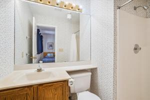 a bathroom with a sink and a toilet and a mirror at Charming 2-Bedroom Slopeside at Pico Mountain E304 in Killington +34 photos