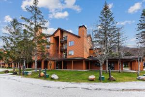 a large brick building with trees in front of it at Spacious & cheerful Pico slopeside Condo Walk to lift & ski back! Pico 304 in Killington