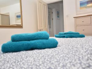 two blue towels on a bed with a mirror at 4 Bed in Ilfracombe 45121 in Ilfracombe