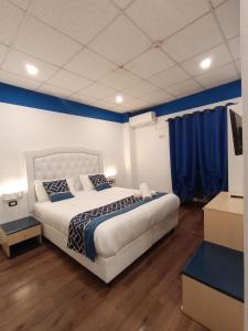 a bedroom with a large bed with blue walls at Hotel Veronese in Genoa