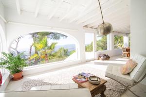 a living room with a couch and a large window at Villa Tikal in Can Furnet