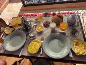 una mesa con platos de comida en una mesa en Riad au cœur de la médina loué entièrement avec ménage et petit déjeuner compris, en Marrakech
