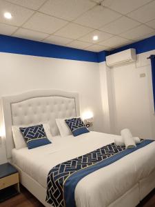 a bedroom with a large white bed with blue walls at Hotel Veronese in Genoa
