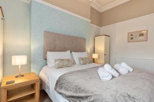 ein Schlafzimmer mit einem großen Bett mit zwei Kissen in der Unterkunft Spinnaker - Close to Town Sea Views in Tenby