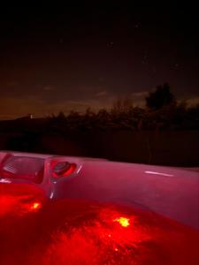una luce rossa sul retro di un'auto di notte di Luxury Home with Jakuzzi near Neusiedler See a Fertőszentmiklós