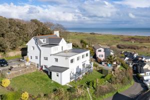 uma vista aérea de uma casa branca com o oceano ao fundo em The Cwtch Apartment - Sea Views Walk to Beach em Penally