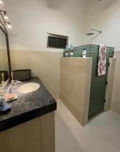baño con lavabo y nevera verde en Villa Bianca Bacalar, en Bacalar
