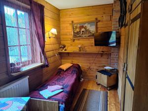 a small bedroom with a bed and a television at Dom Gościnny Dudek in Krynica Zdrój +89 photos