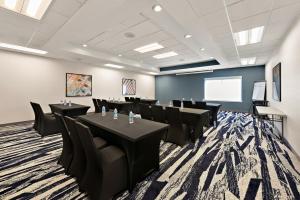 a conference room with tables and chairs and a screen at Comfort Suites Columbus East Broad in Columbus