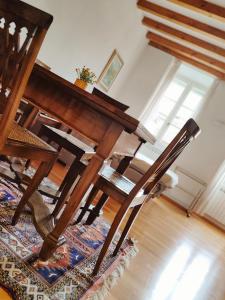 a wooden dining room table with a chair and a rug at 1Dest - City Center Charme in Riva del Garda +12 photos