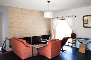 ヴィゼラにあるQuinta Da Longraのリビングルーム(オレンジ色のソファ、暖炉付)