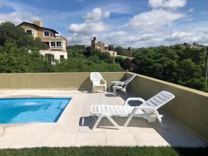 two chairs and a swimming pool on a balcony at Casaabril in Villa Carlos Paz