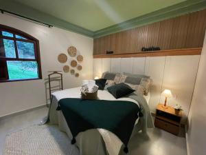 1 dormitorio con cama y ventana en Vale Zirá en Vassouras