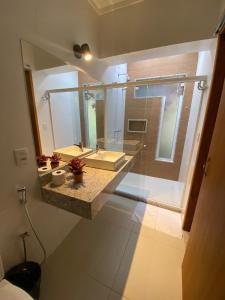 a bathroom with a glass shower and a sink at Vale Zirá in Vassouras
