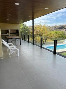 Habitación con mesa, sillas y piscina en Casaabril en Villa Carlos Paz