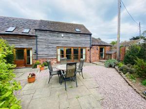 Rytonにある2 Bed in Shrewsbury 47795の家の前にテーブルと椅子が置かれたパティオ