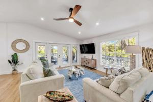 a living room with two couches and a ceiling fan at Surf Side in Anna Maria
