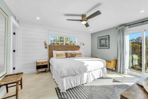 a bedroom with a bed and a ceiling fan at Surf Side in Anna Maria +57 photos