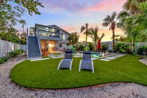 a house with two lawn chairs and a pool at Surf Side in Anna Maria