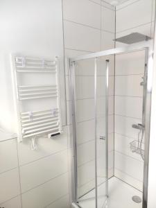 une douche avec une porte vitrée dans une salle de bain dans l'établissement Ferienhaus Mila 70qm bis 5 Gäste mit Fass-Sauna, Whirlpool April bis Oktober, 75qm Terrasse und eingezäunten Garten Haustiere willkommen, à Sierosław