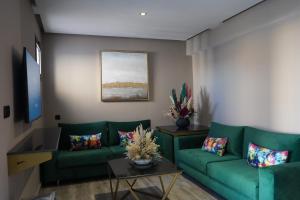 - un salon avec un canapé vert et une table dans l'établissement Super appartement avenue hassan 2, à Agadir