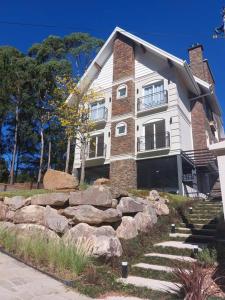 una casa grande con rocas delante en Pervoi Casa Ipê, en Gramado