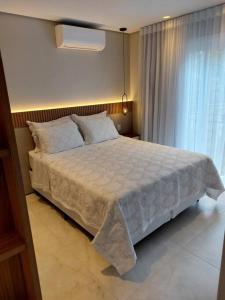 Un dormitorio con una cama grande y una ventana en Pervoi Casa Ipê, en Gramado