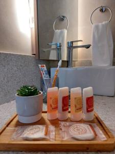 a bathroom counter with a cutting board with towels and a sink at Pervoi Casa Ipê in Gramado