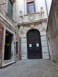 ヴェネツィアにあるロカンダ カ   フォルモーザの黒い扉付き建物の入口