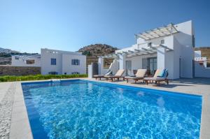 a swimming pool in front of a villa at Natura Villas in Naxos in Mikri Vigla