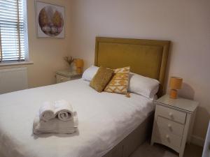 a bedroom with a large bed with towels on it at Modern large 2 Bed whole apartment - Free parking - Ground floor - Central Beeston in Nottingham
