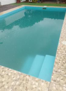 una piscina de agua azul en un patio en Macrigaluma Sol, en Barra del Chuy