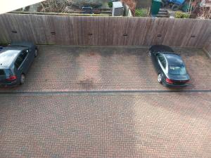 two cars parked on a brick parking lot at Modern large 2 Bed whole apartment - Free parking - Ground floor - Central Beeston in Nottingham
