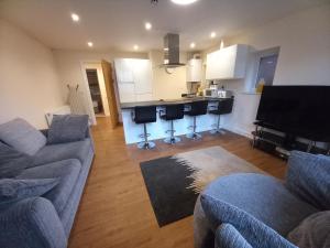 a living room with a couch and a kitchen with a piano at Modern large 2 Bed whole apartment - Free parking - Ground floor - Central Beeston in Nottingham