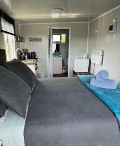 a bedroom with a large bed with two towels on it at Raglan Seaview Cabin in Raglan