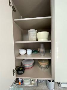 a kitchen pantry with bowls and plates on shelves at Charming City Home Near Downtown with Garage in Amiens