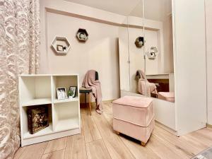 um quarto com uma cadeira rosa e um espelho em New Stylish Apartment City Center em Narva