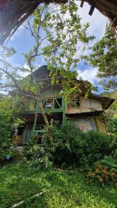 una casa con una pintura verde a un lado. en Ecofinca in the mountains Azulita House, en Cocorná