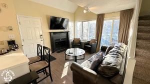 un soggiorno con divano in pelle e camino di Mountainview Loft at North Creek Resort a Blue Mountains