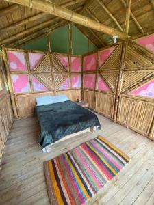 a bed in a large wooden room with a rug at Ecofinca in the mountains Azulita House in Cocorná