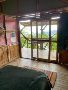 a room with a large window and a bed in it at Ecofinca in the mountains Azulita House in Cocorná