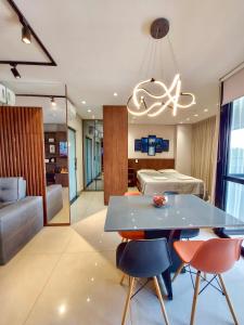 een woonkamer met een tafel en stoelen en een bed bij Vertigo Premium Studios - Luxo e Praticidade in Campo Grande