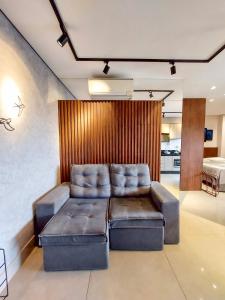 een woonkamer met een bank in een kamer bij Vertigo Premium Studios - Luxo e Praticidade in Campo Grande