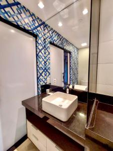 a bathroom with a white sink and a mirror at Vertigo Premium Studios - Luxo e Praticidade in Campo Grande