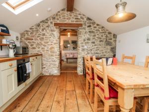 a kitchen and dining room with a wooden table and chairs at Hay Loft in Camborne