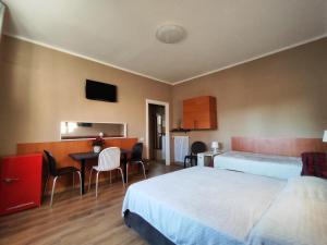 Cette chambre d'hôtel comprend deux lits, une table et des chaises. dans l'établissement B&B Bella Garbatella, à Rome
